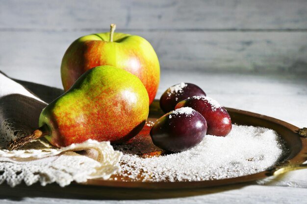 tasty fresh fruits with sugar on tray on wooden table