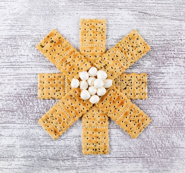 Top view crackers with mozzarella on white wooden  horizontal