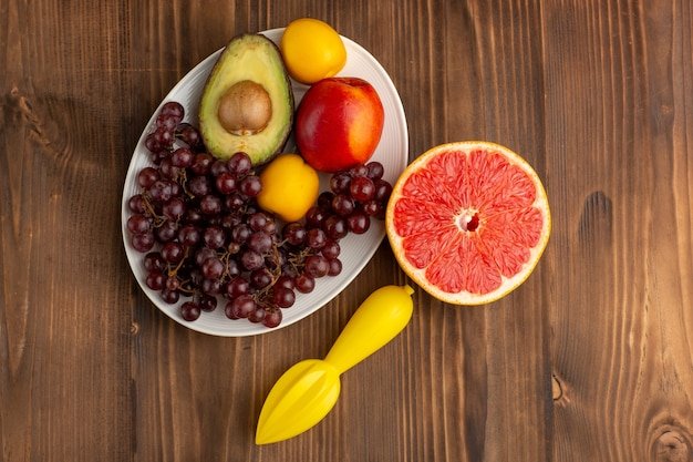 Top view different fruits with grapefruit on brown wooden desk