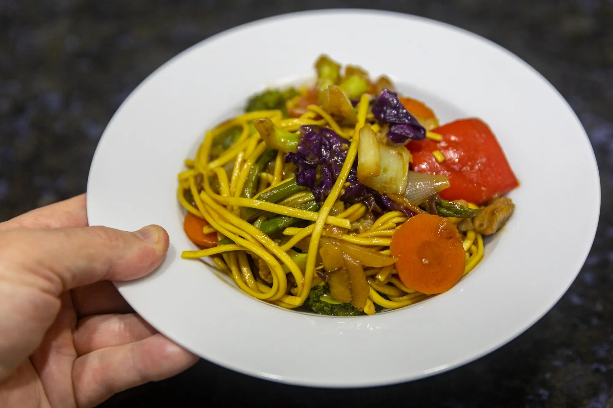 Traditional oriental yakisoba on white plate in selective focus