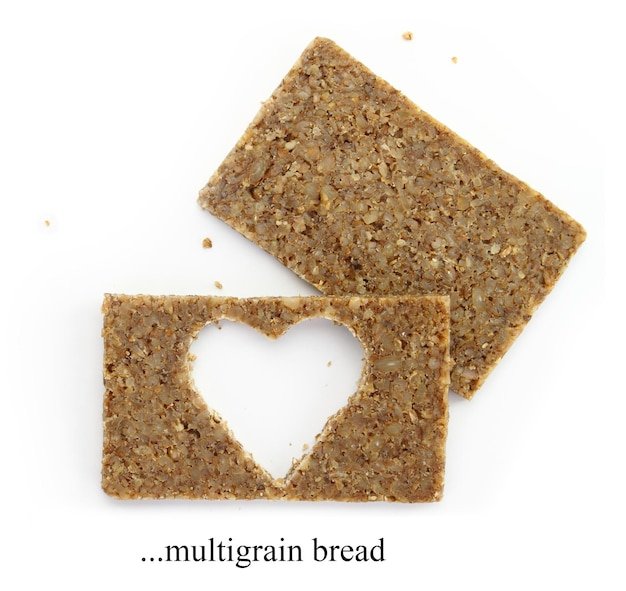 Two multigrain slices of bread with cut out shape of heart isolated on white