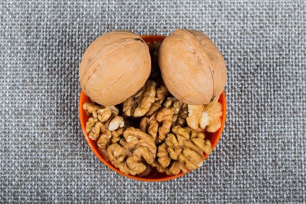 Whole walnuts and kernels on burlap background healthy food