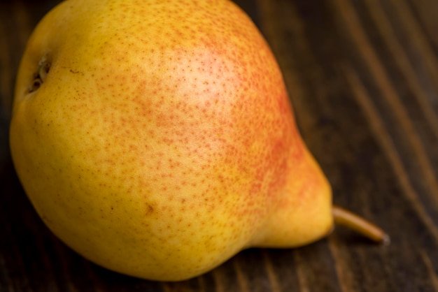 A yellow ripe pear with a red side on the table a harvest of fresh crispy pears during cooking