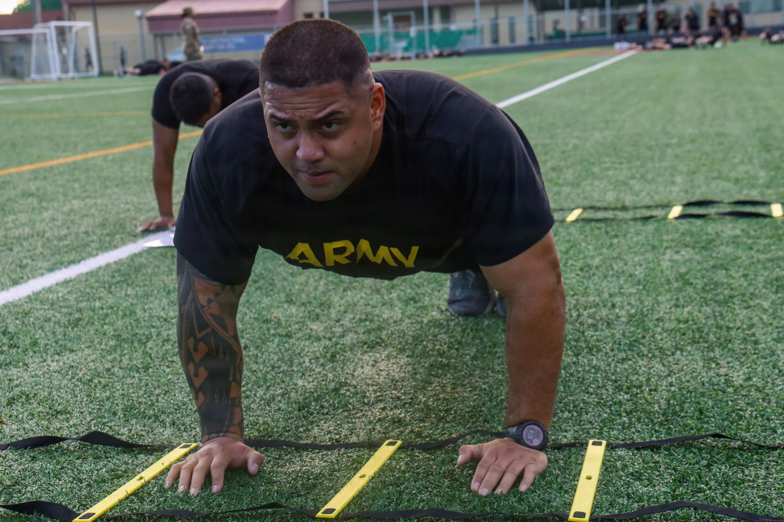 U.S. Army Staff Sgt. Kawika Fuga, master driver, G-3, 19th Expeditionary Sustainment Command, performs a hand walk through an agility ladder during section physical training, July 28, 2026, at Kelly Field on Camp Walker, Daegu, Republic of Korea. The movement challenges the shoulders, chest, triceps and core while developing the coordination needed to remain effective under physical stress. (U.S. Army photo by Sgt. Deziree Keay)