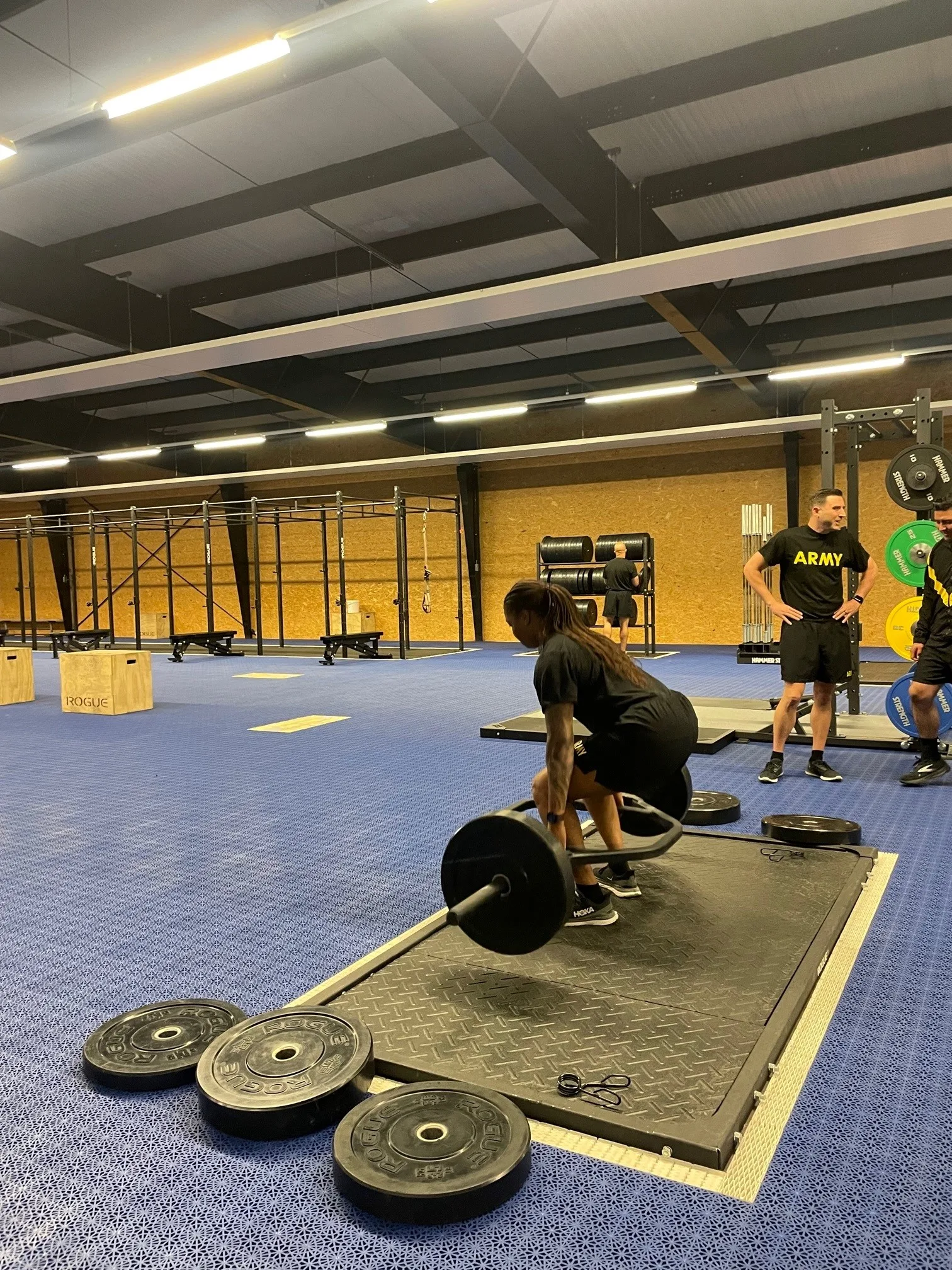 Soldiers from Headquarters and Headquarters Company (HHC), U.S. Army Garrison Rheinland-Pfalz, conducted the Army Combat Fitness Test (ACFT) using the recently upgraded Functional Fitness Training Center (FFTC) on Rhine Ordnance Barracks (ROB) Aug. 9.
Staff Sgt. Francesca Cyma, Supply Specialist for HHC Rheinland-Pfalz performs the 3 Repetition Maximum Deadlift (MDL) event. The MDL assesses the muscular strength component of fitness by measuring a Soldier’s lower body, grip and core muscular strength. It requires well-conditioned back and leg muscles and helps Soldiers avoid hip, knee and lower back injuries. Flexibility and balance are secondary components of fitness assessed by the MDL. (Photo by Gabriela Montanez)
