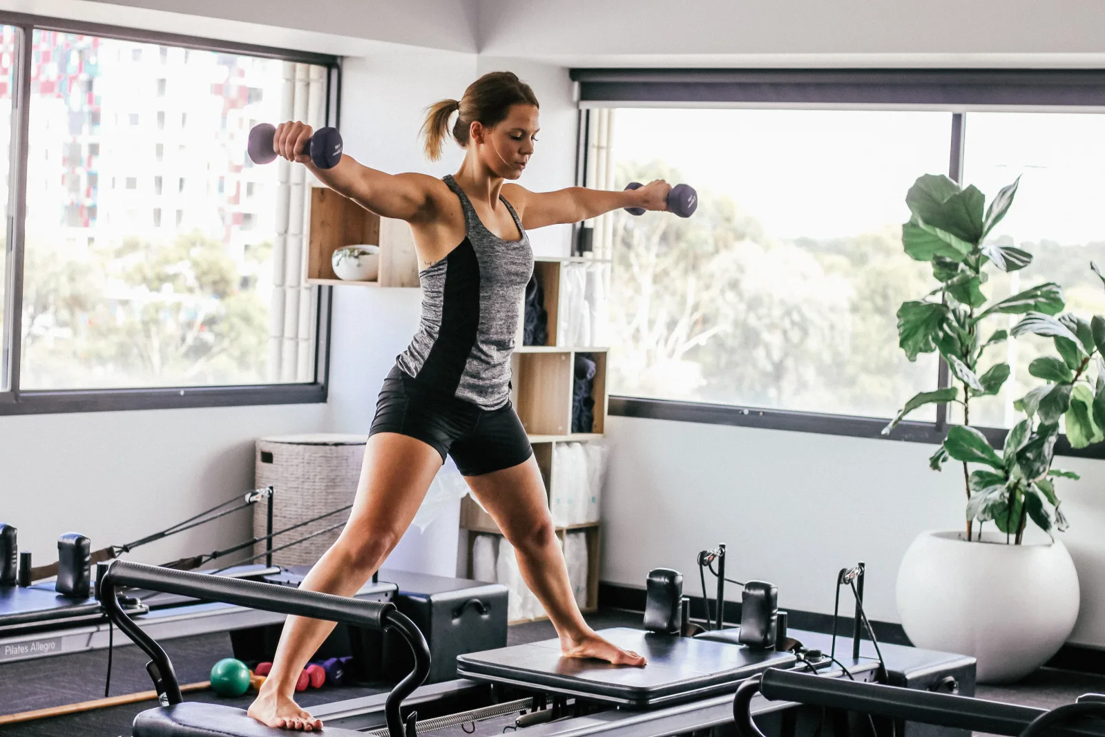Woman using pilates reformer which improves core strength and overall coordination.