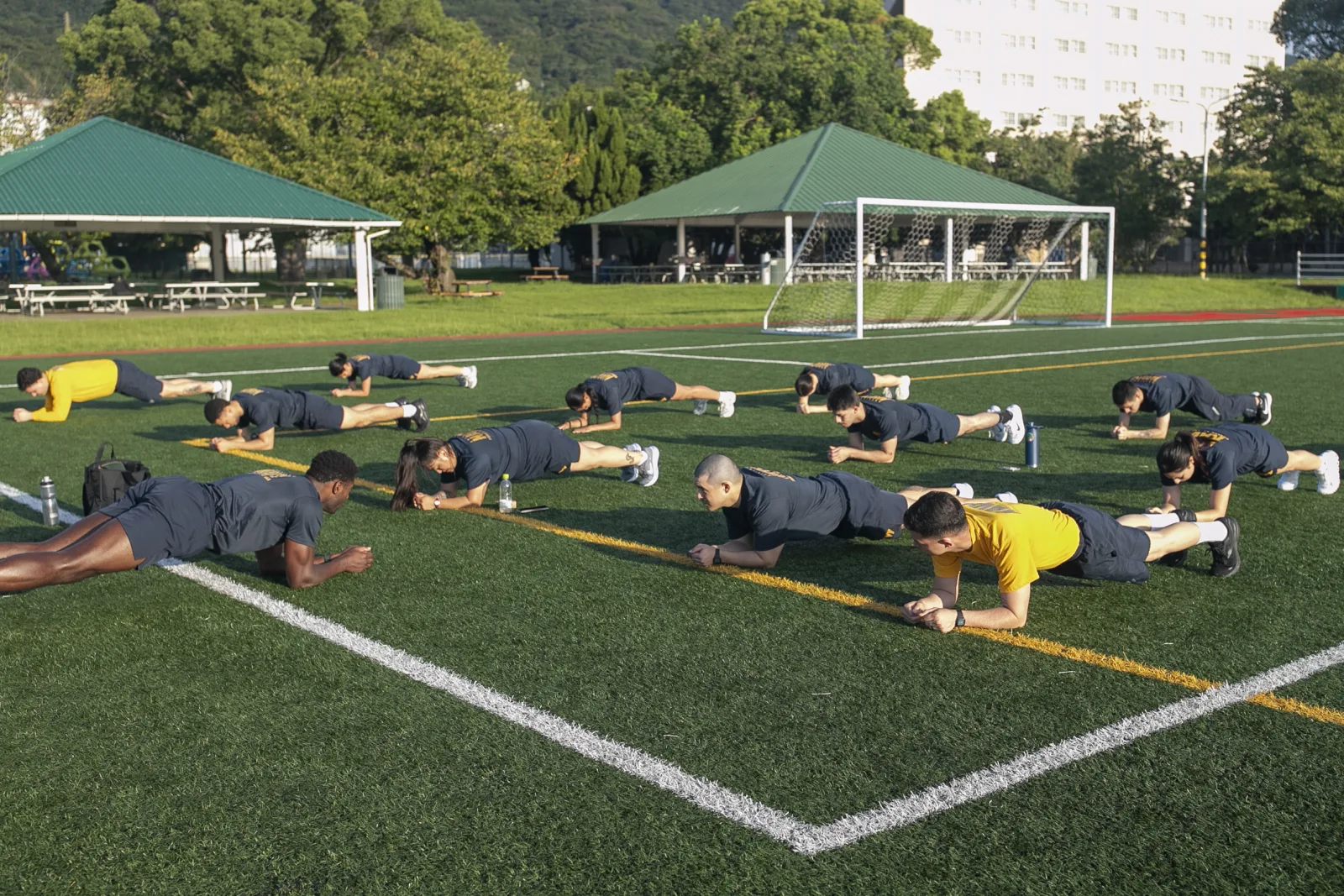 Sailors assigned to amphibious assault carrier USS Tripoli (LHA 7), perform warm-up stretches during the physical readiness test at Nimitz Park in Sasebo, Japan Sep. 22, 2025. Tripoli is forward deployed to Sasebo, Japan, and operates in U.S 7th Fleet, the U.S Navy’s largest forward-deployed numbered fleet, which routinely interacts and operates with allies and partners in preserving a free and open Indo-Pacific region. (U.S. Navy photo by Mass Communication Specialist Seaman Paul LeClair)