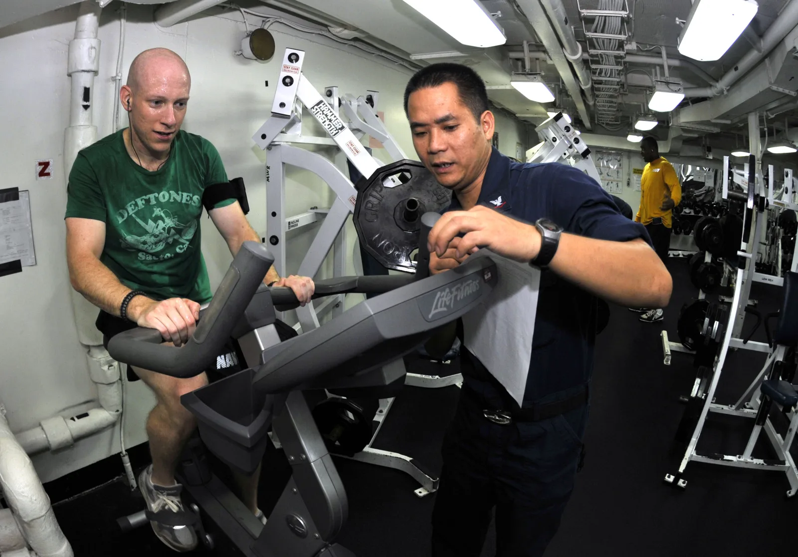 PACIFIC OCEAN (Oct. 24, 2010) Lt. j.g. Neal Soladay, left, from Columbia, S.C., finishes his 20-minute cycle on an exercise bicycle during an indoor triathlon in the gym aboard the aircraft carrier USS George Washington (CVN 73). The triathlon required participants to spend 20 minutes on the treadmill, bicycle and rowing machine. George Washington, the Navy's only permanently forward-deployed aircraft carrier is underway helping to ensure security and stability in the western Pacific Ocean. (U.S. Navy photo by Mass Communication Specialist 3rd Class David A. Cox/Released)
