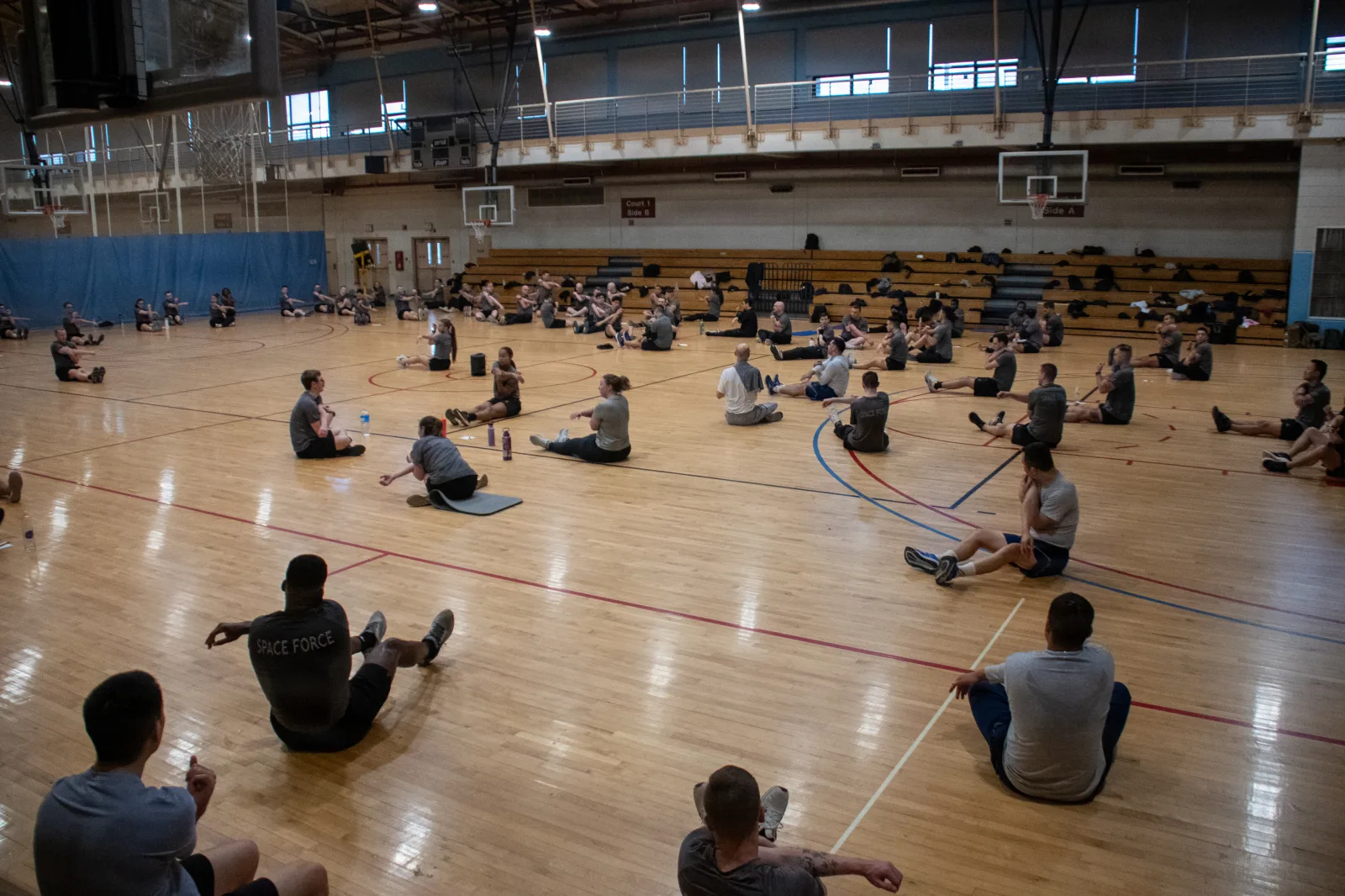 Guardians and Airmen attached to U.S. Space Forces - Korea stretch during unit physical training at Osan Air Base, Republic of Korea, Feb. 26, 2026. The training involved mobility exercises and injury prevention to keep the force fit and mission ready for operations on the Korean Peninsula. (U.S. Space Force photo by 1st Lt. Jimmy Nguyen)