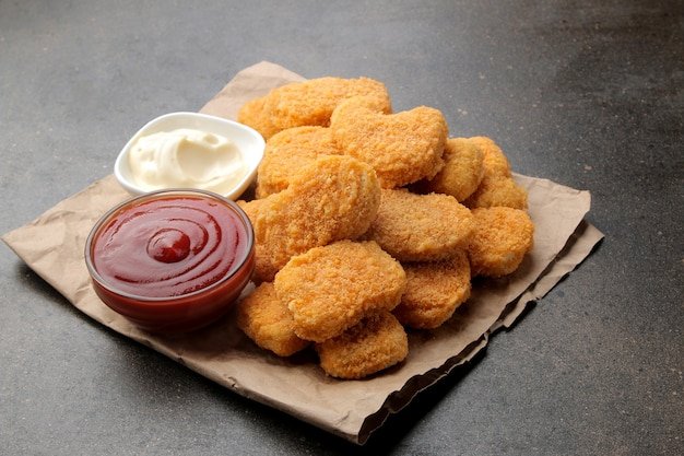 Chicken nuggets with white and red sauce on a brown background. fast food