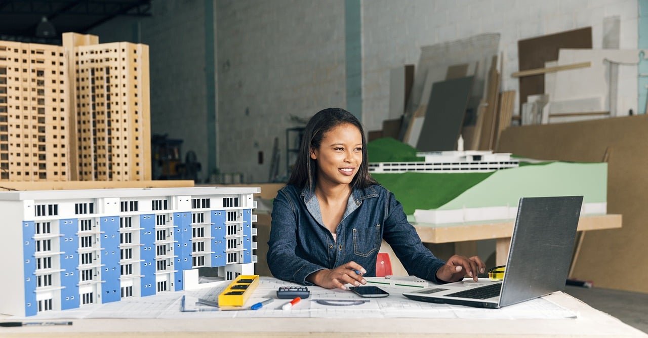 architecture, architect, project, office, desk, building model, project on paper, computer, woman, smiling, office furniture, plans, drawing, interior design, workspace, graphic design, drafter, professional, wall, ai generated