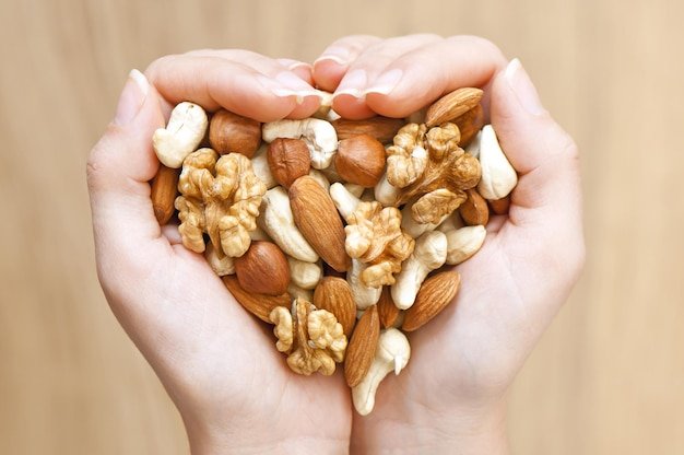 Handful of mixed nuts in heart shape healthy food concept