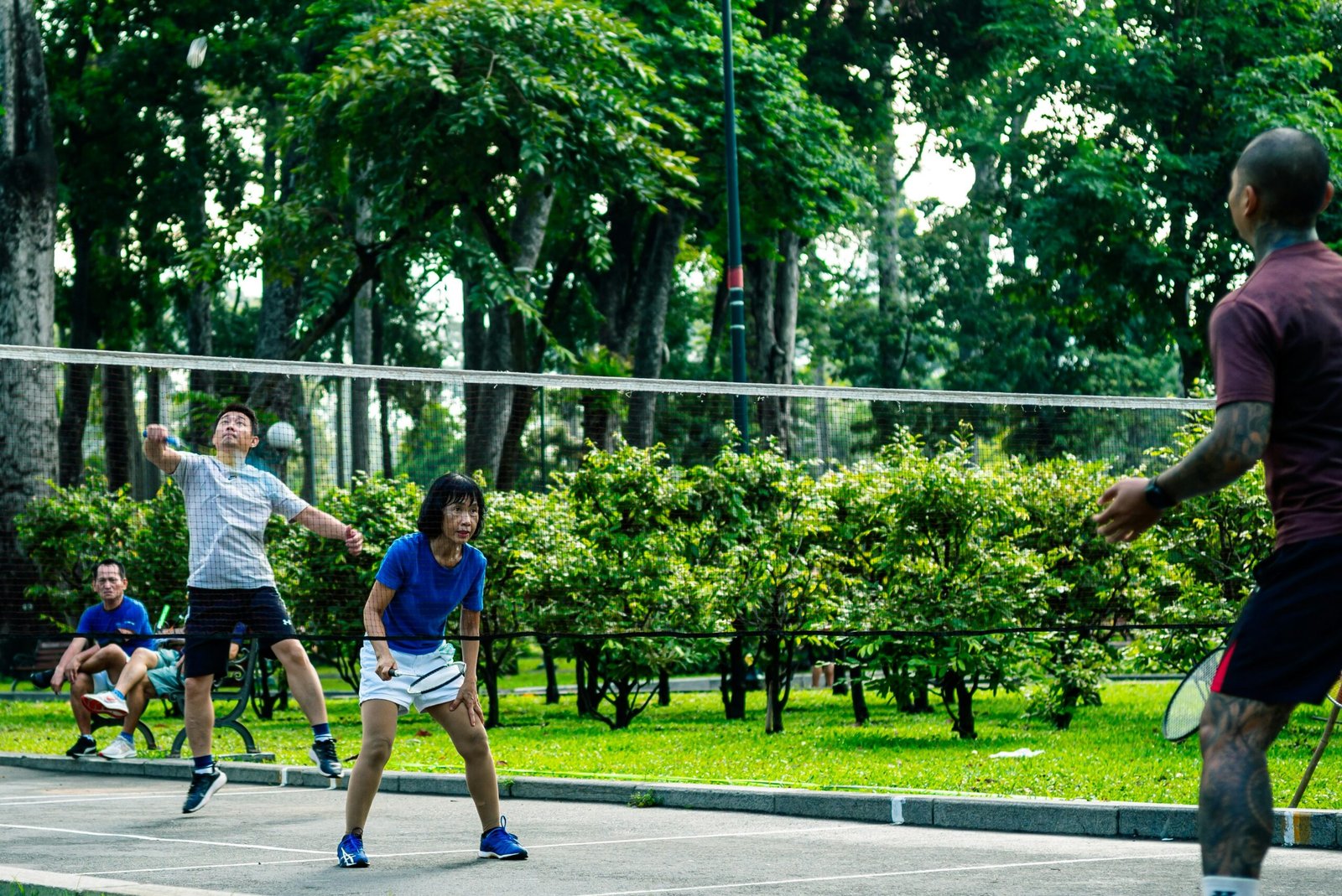 People playing badminton in a park.