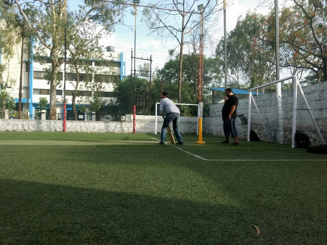 Two men playing cricket on a turf field.