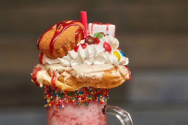 Marshmallow milk shake cocktail with whipped cream, cookies, muffin and treats