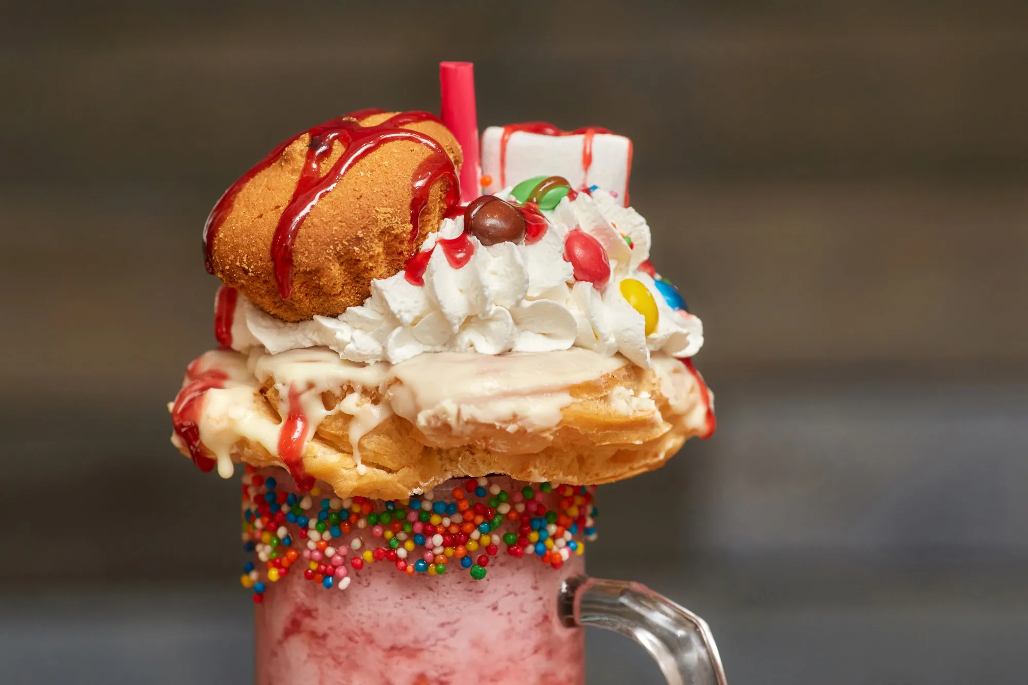 Marshmallow milk shake cocktail with whipped cream, cookies, muffin and treats