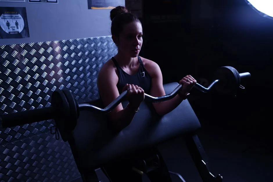 Focused woman weightlifting with barbell in a Paris gym, highlighting strength and determination.