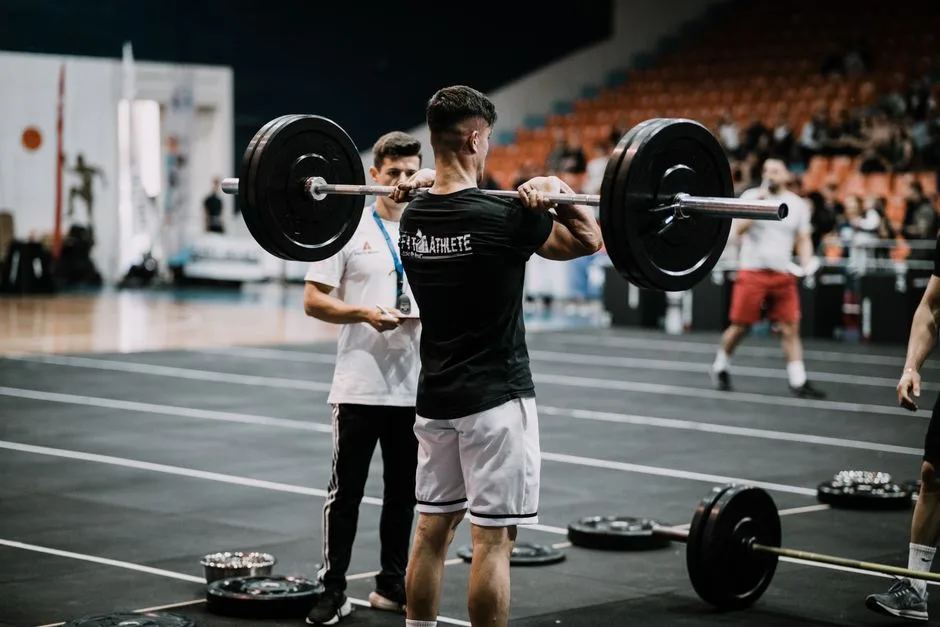 An athlete performs a challenging lift during a weightlifting competition indoors.