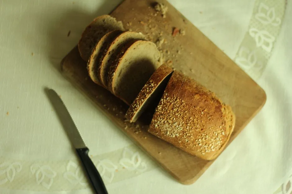 Close-up of sliced whole wheat bread on a wooden cutting board, perfect for culinary themes.