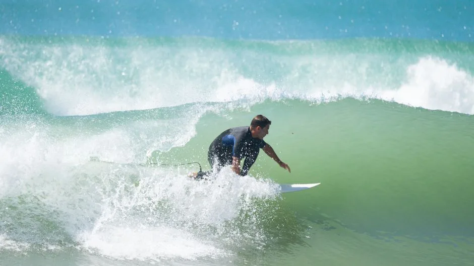 A surfer skillfully rides a powerful ocean wave, showcasing thrilling action.