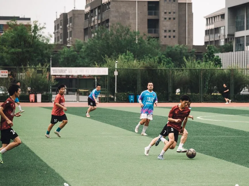 Players engaged in a lively amateur soccer match on an urban outdoor field.