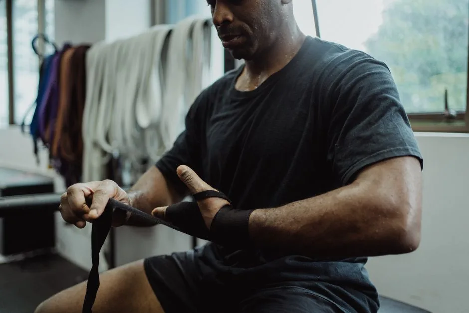 Focused man wraps wrists in sports gym, ready for strength training.