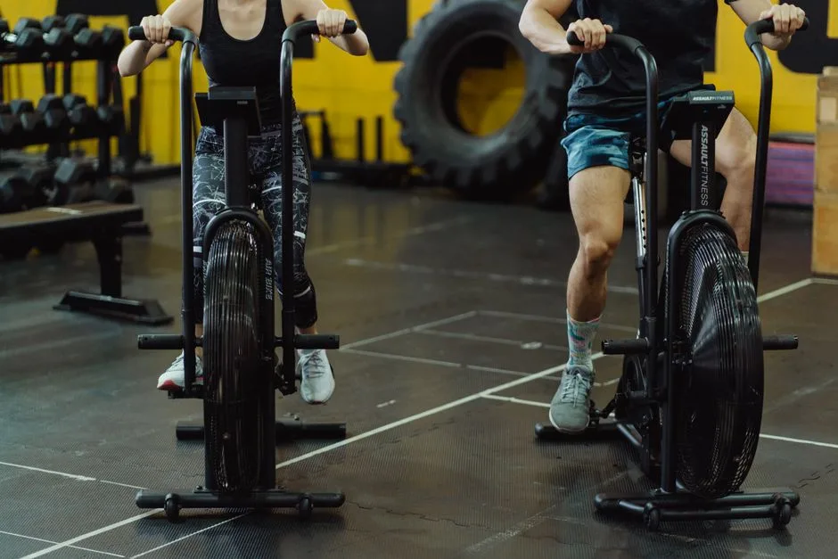 Two people exercising on stationary bikes at a modern gym.