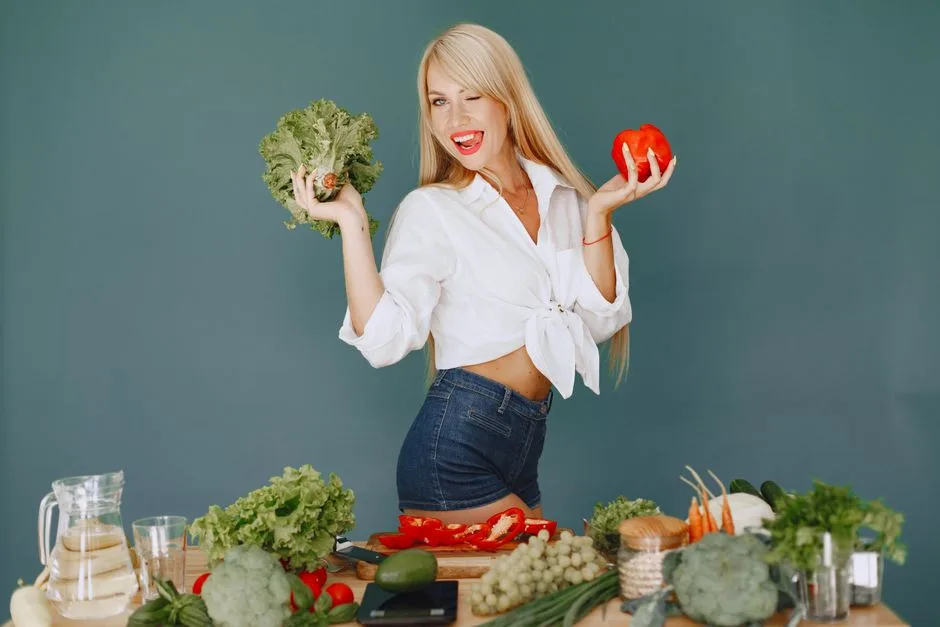 Cheerful woman in white shirt holding lettuce and pepper, celebrating fresh vegetables.