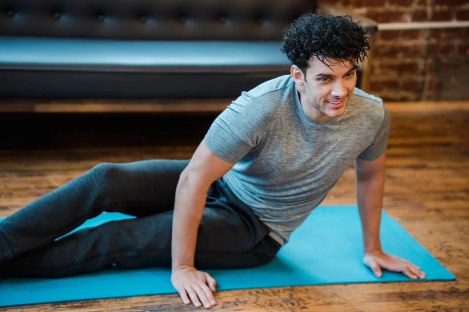 High angle of positive male training on sports mat at spare time and looking away