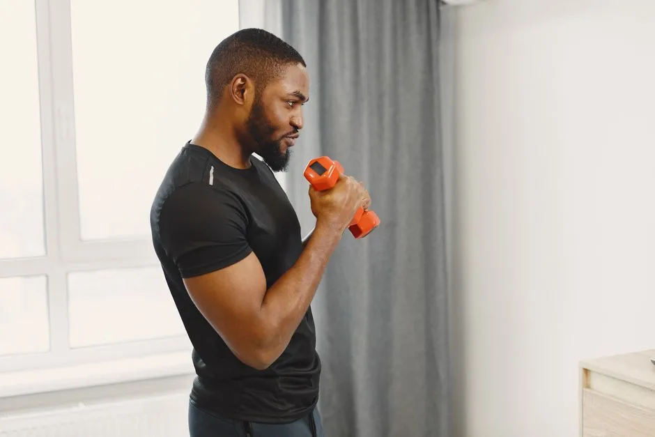 African American man exercising with a dumbbell indoors. Fitness and healthy lifestyle concept.