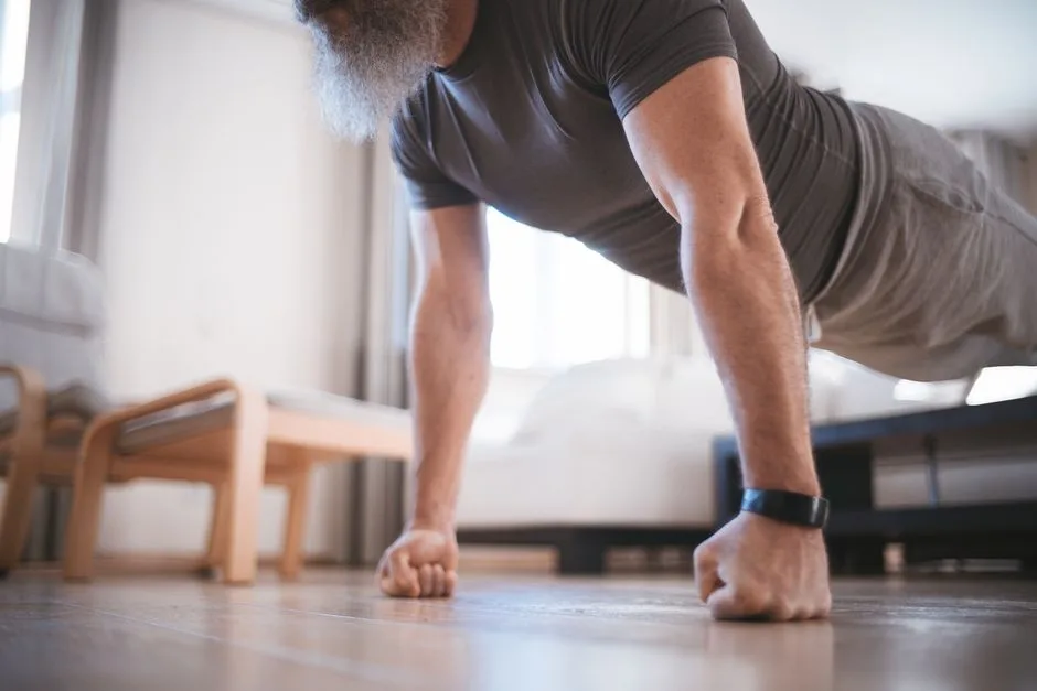 A senior man performing push-ups on the floor of his living room for fitness.