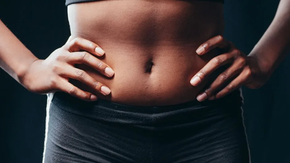 A close-up shot of hands on an athletic abdomen, symbolizing fitness and health.