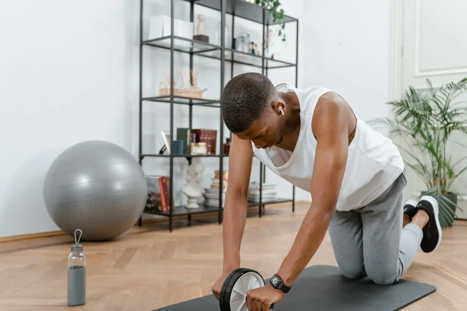 Adult male using an ab wheel for exercise in a home gym setting, focusing on fitness.