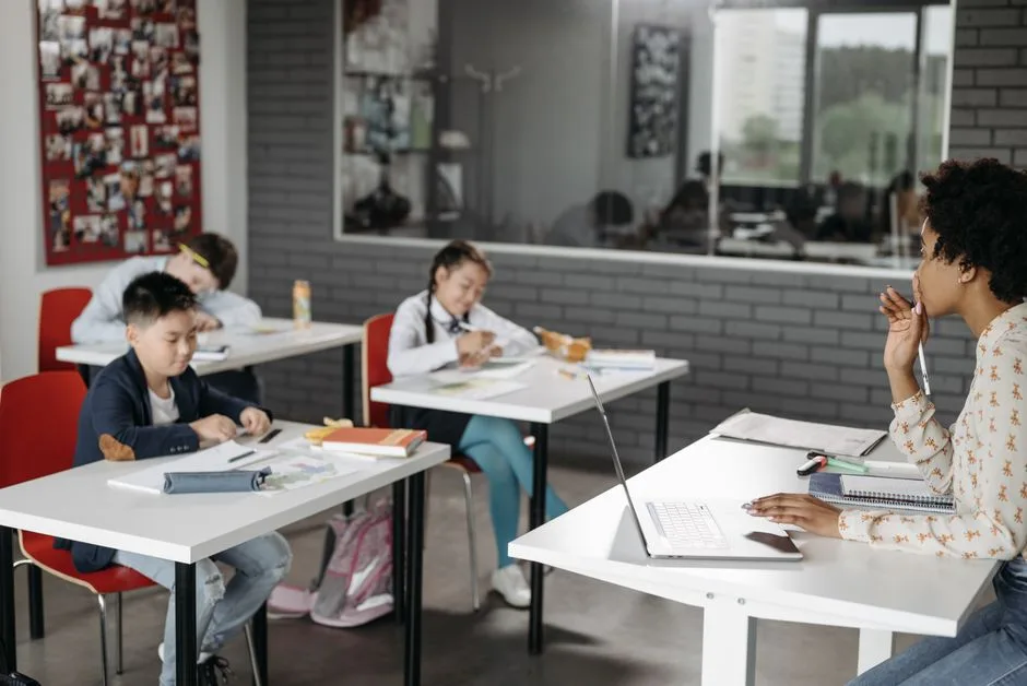 A classroom scene with a teacher and students engaged in learning activities.