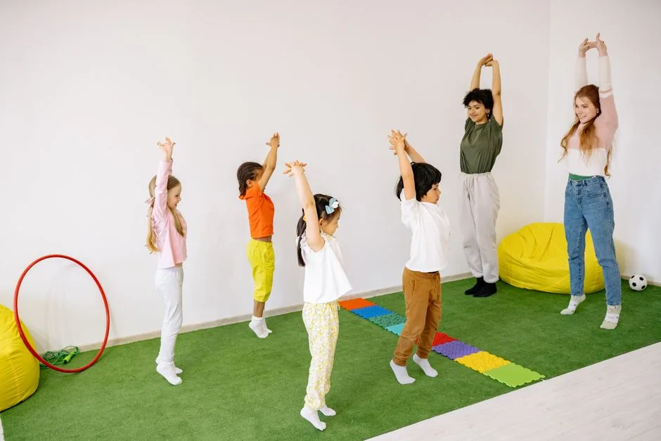 Kids and teachers doing stretching exercises in a vibrant indoor classroom setting.