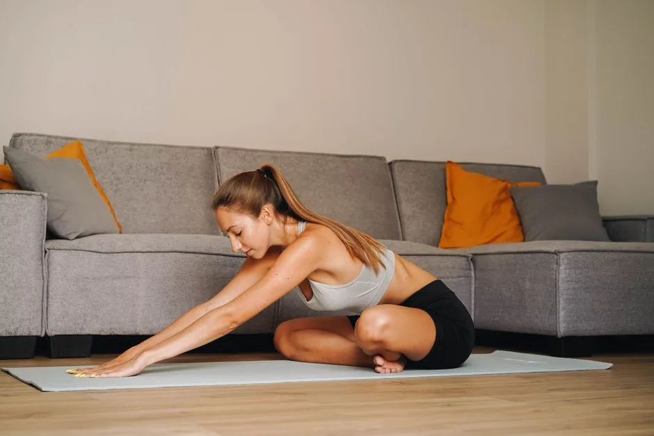 Woman practicing yoga indoors on a mat in a modern living room, embodying a healthy lifestyle.