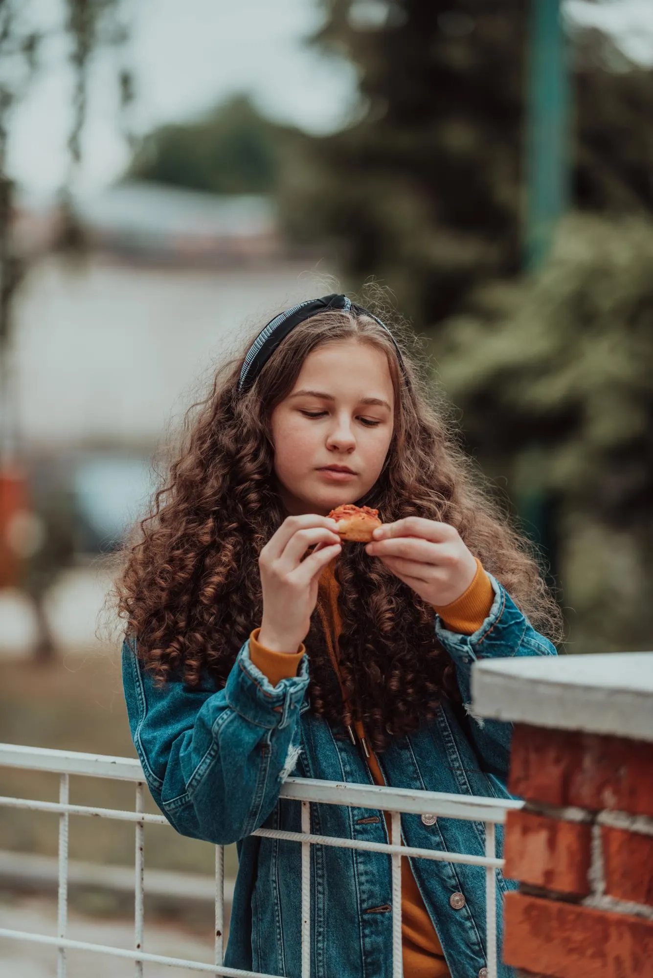 A portrait of a girl eating pizza on a lunch break at school during the gradual opening after the closure of the pandemic Selective focus High quality photo