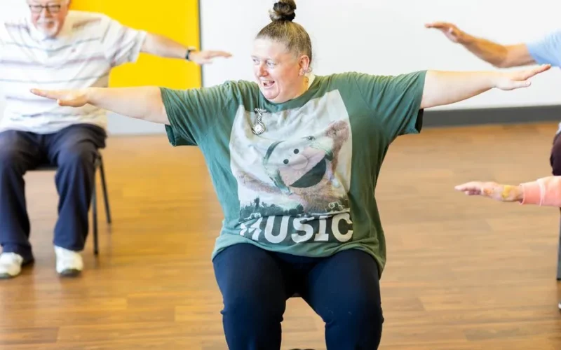 Seniors participating in a seated exercise class, promoting community health and active aging.