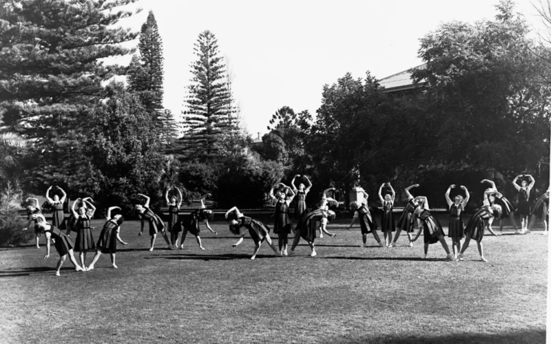 In this photo students of the Adelaide Teachers College undertake an exercise drill or possibly a dance class. The positions they are holding are similar to ballet techniques. These exercises would have then been taught to the students as a part of the standard South Australian education curriculum.