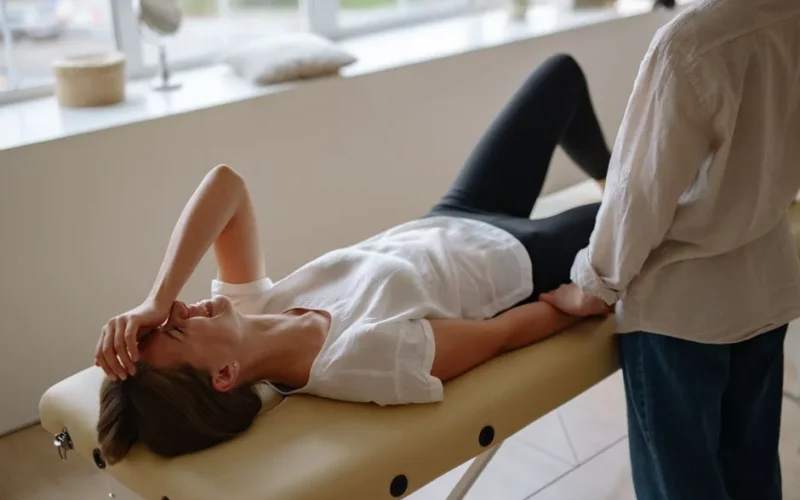 Woman in white top enjoying a relaxing massage session indoors, smiling and lying comfortably.