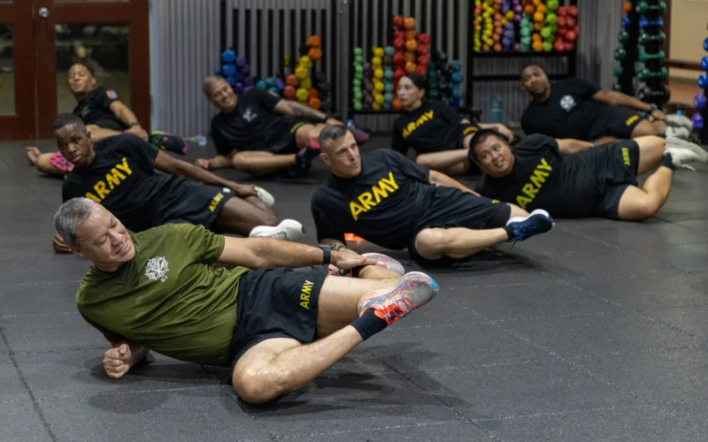 U.S. Army Sgt. Maj. Christopher P. Stevens, Deputy Chief of Staff, G1 Sergeant Major, performs the thigh stretch exercise during Physical Readiness Training (PRT) recovery drills with Eighth Army HQDA G1 and Eighth Army HR soldiers at Collier Community Fitness Center Camp Humphreys, South Korea, Sept. 25, 2025. The event featured multiple workout stations designed to build esprit de corps and maintain physical fitness. This joint training highlights the commitment of both HQDA and Eighth Army HR professionals to readiness, resilience, and fostering a strong team culture within the Army. (U.S. Army photo by Pfc Eun Jun Choi)