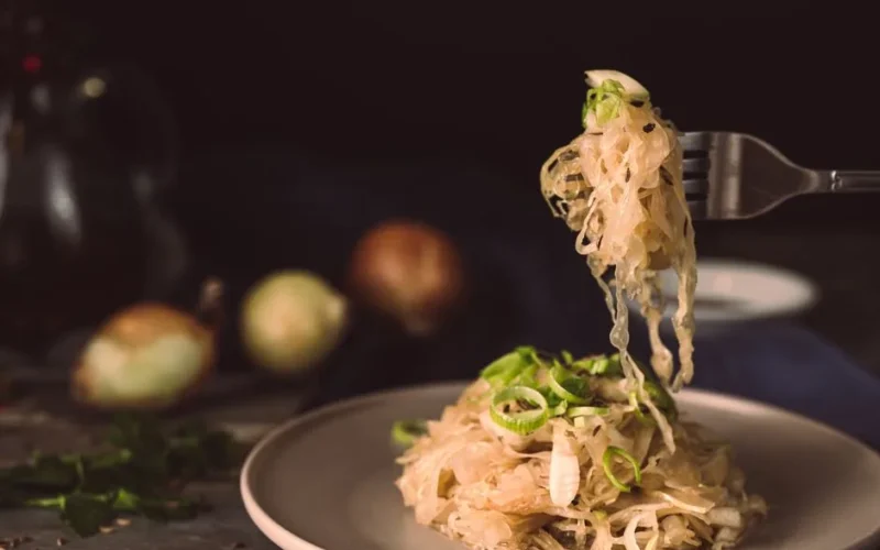 A mouthwatering plate of sauerkraut garnished with green onions, ready to eat.