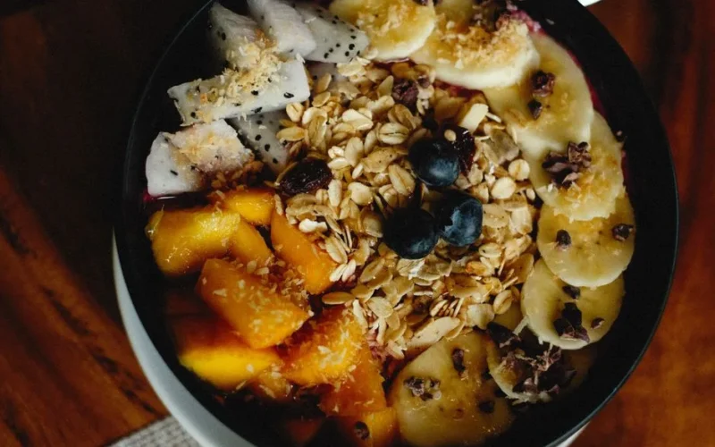 A vibrant breakfast bowl filled with fresh fruits, oats, and granola for a healthy meal.