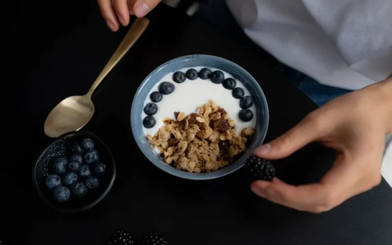 A delicious breakfast bowl featuring granola, yogurt, blueberries, and blackberries, perfect for a healthy start.