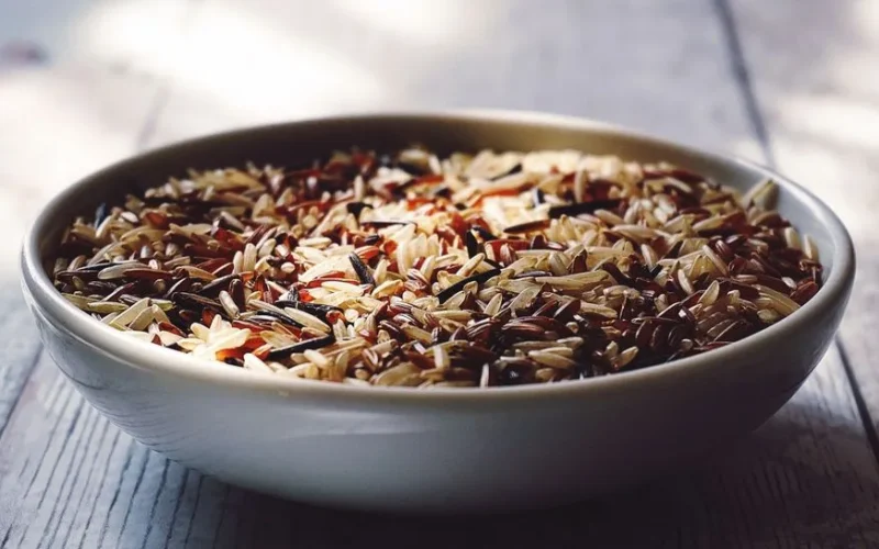 Close-up view of a bowl filled with mixed wild and brown rice grains.