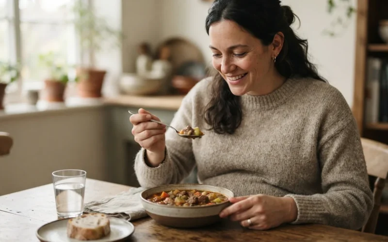 a pregnant woman eating a bowl of stew