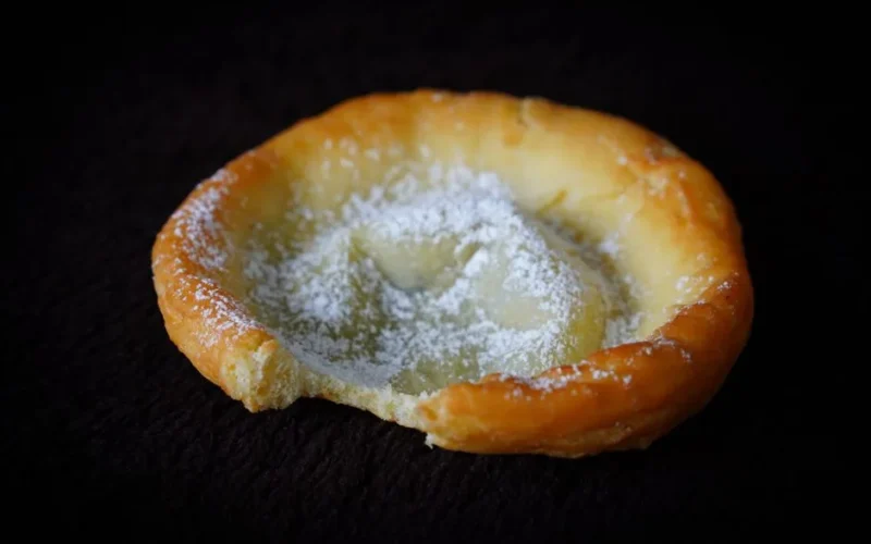 A delicious pastry topped with powdered sugar, showcasing a rustic homemade look.