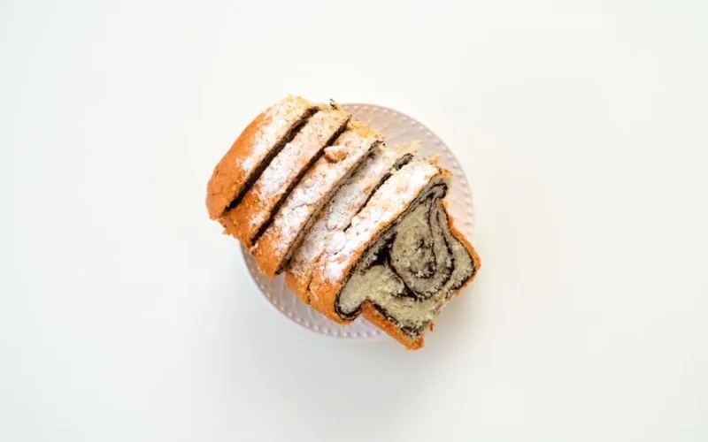 Top view of sliced sweet bread with filling on a plate, ideal for food blogs and culinary websites.