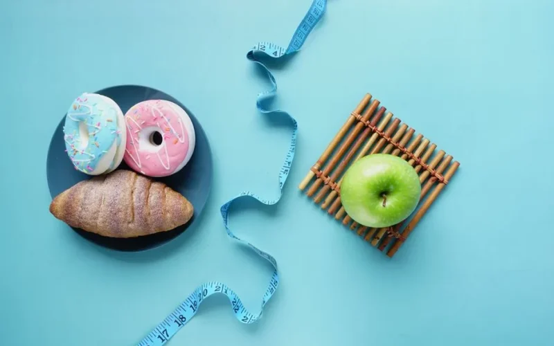 Contrast of healthy and indulgent foods with a measuring tape for weight management.