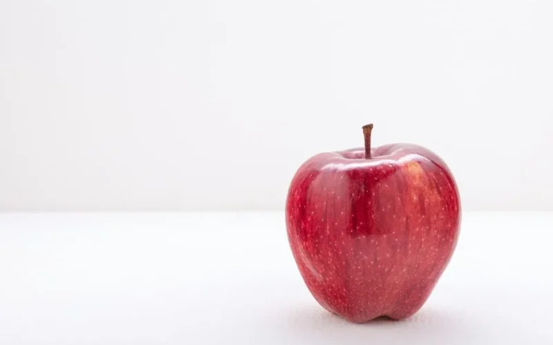 Close-up of a ripe red apple with white background for copy space.